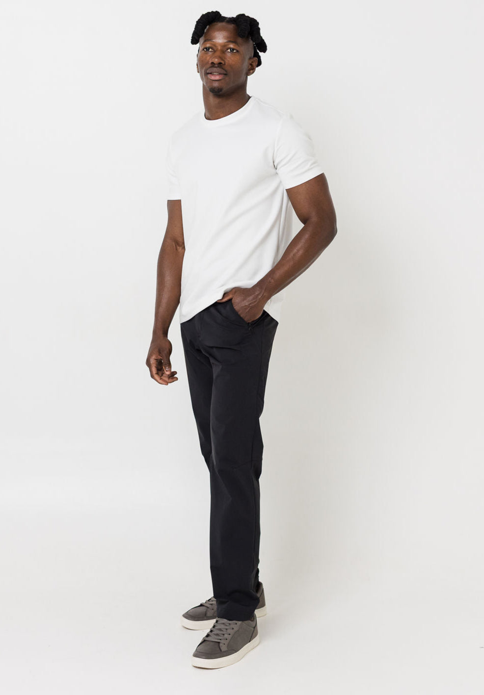 Man wearing a white t-shirt and black pants on a white background