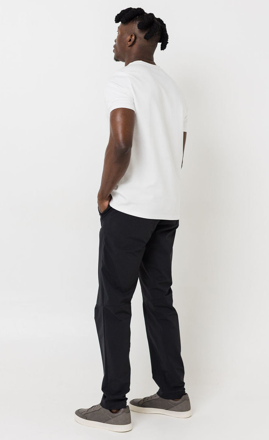 Person wearing a white t-shirt and black pants on a white background