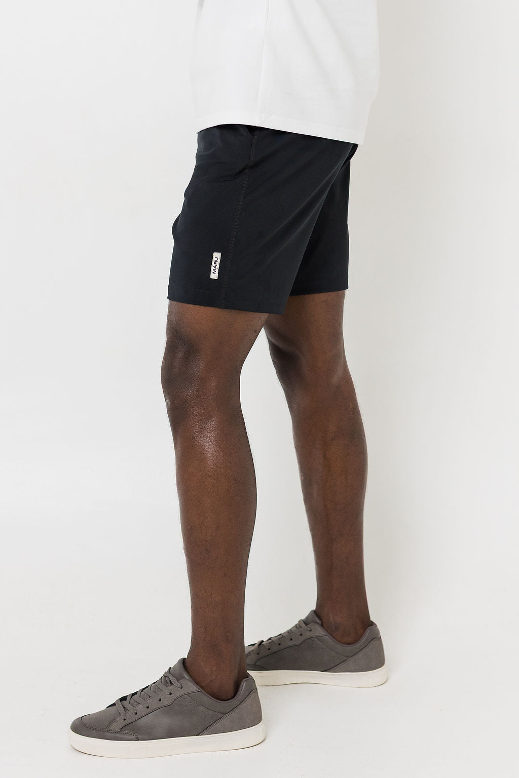 Man wearing black shorts and white t-shirt on a white background