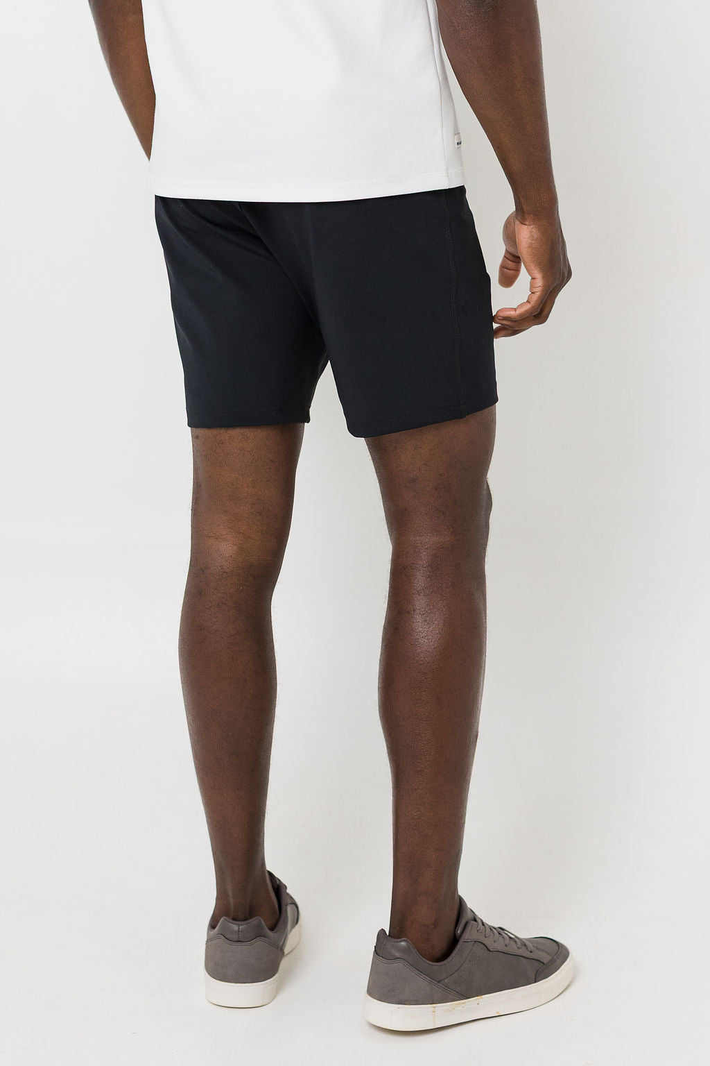 Man wearing black shorts and white t-shirt on a white background