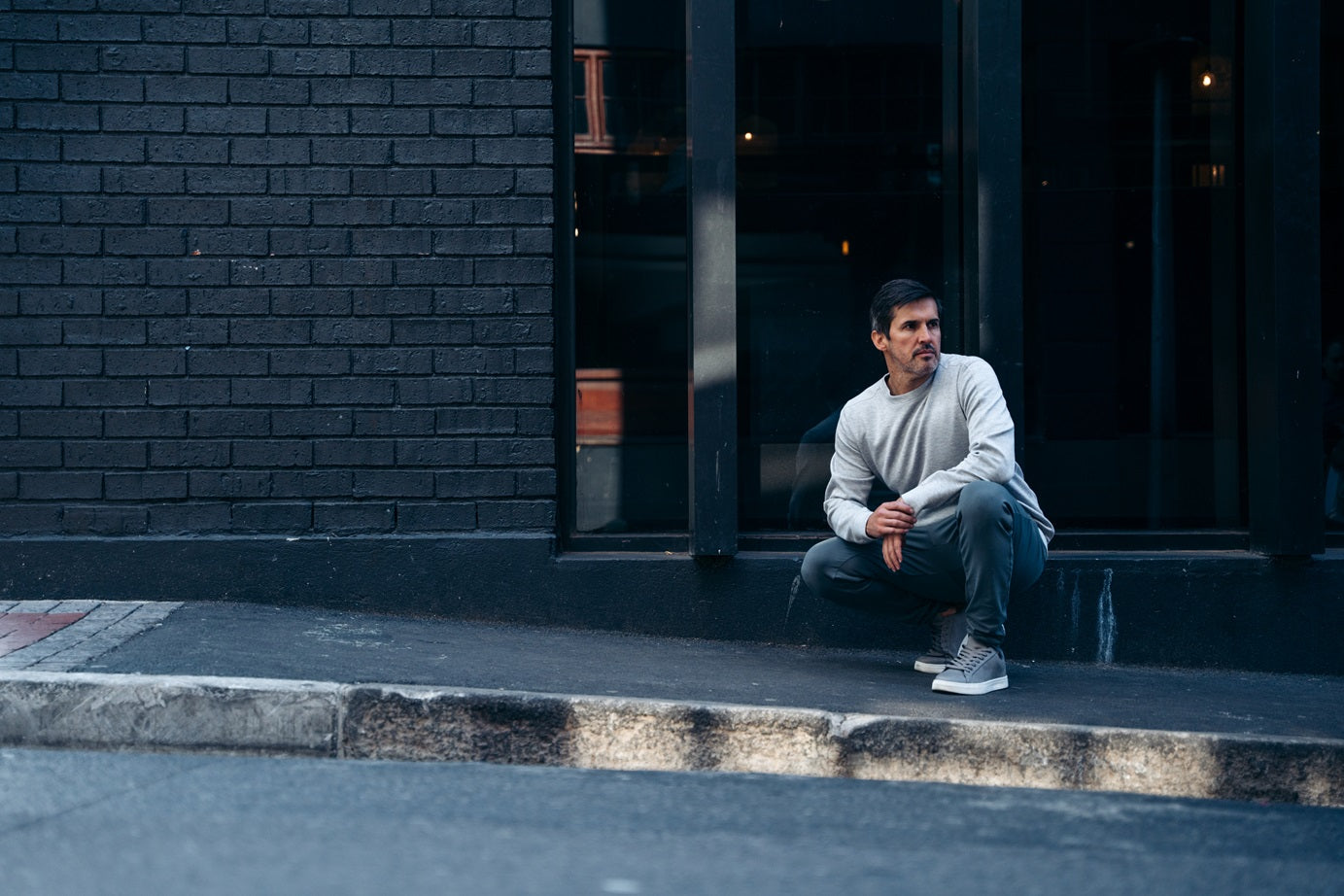 Man crouching down in front of wall Maru Clothing 
